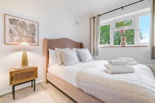 a white bedroom with a large bed with white pillows at Modern 1 bed-Nr Warner Bros-Parking-Garden in Watford