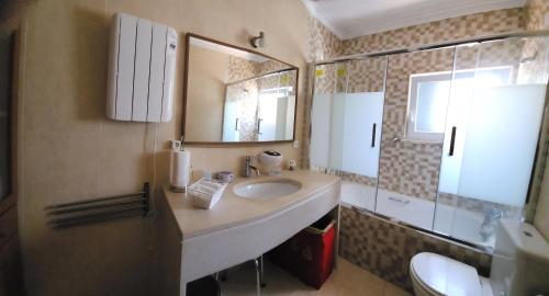 W łazience znajduje się umywalka i lustro. w obiekcie ALOJAMENTO -GUEST HOUSE - Caparica - Trafaria - Surf Sun and Lisbon Lovers w mieście Trafaria