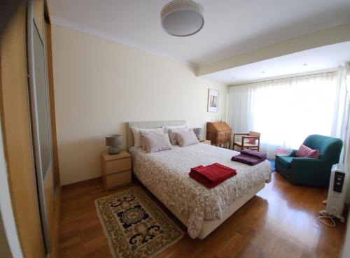1 dormitorio con cama, sofá y ventana en ALOJAMENTO -GUEST HOUSE - Caparica - Trafaria - Surf Sun and Lisbon Lovers, en Trafaria