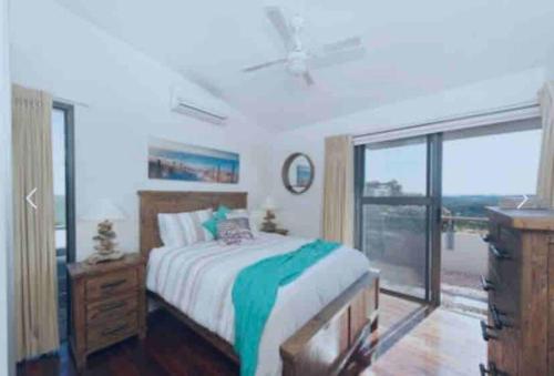 a bedroom with a bed and a large window at The Deckhouse in Boat Harbour