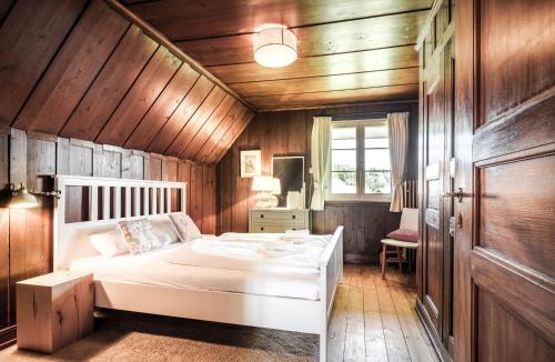 1 dormitorio con cama blanca y paredes de madera en Villa Bergfriede - 5 Schlafzimmer - Feldberg im Schwarzwald, en Hinterfalkau