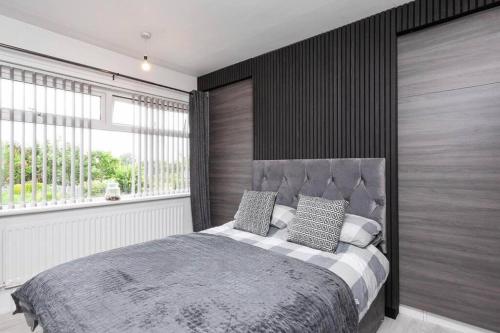 a bedroom with a large bed and a large window at Modern home 10 mins to Belfast City in Belfast