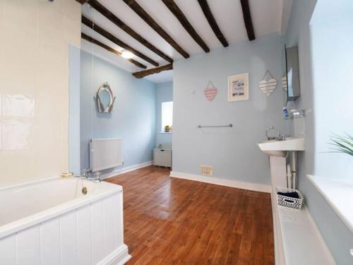 a living room with a wooden floor and a sink at Characterful 3 Bedroom Cottage in Aberystwyth