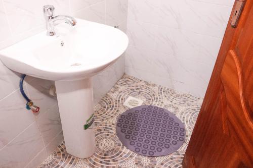 a bathroom with a white sink and a purple rug at BASICS HOME STAYS in Nairobi