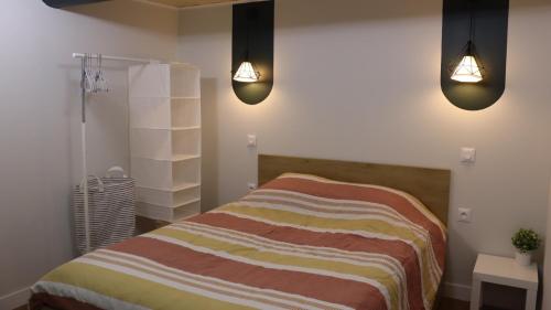 um quarto com uma cama com duas luzes em Studio rénové maison de village du Luberon em Villelaure
