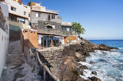 a building on a cliff next to the ocean at La Terraza del Mar in Bocacangrejo