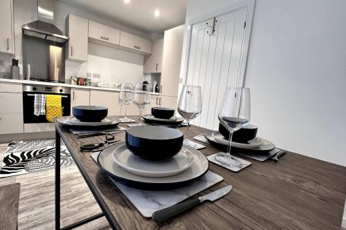 a wooden table with plates and wine glasses on it at The Bootle House in Litherland