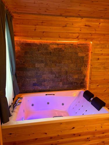 a bath tub in a room with a brick wall at Ria süit otel bungalov in Rize