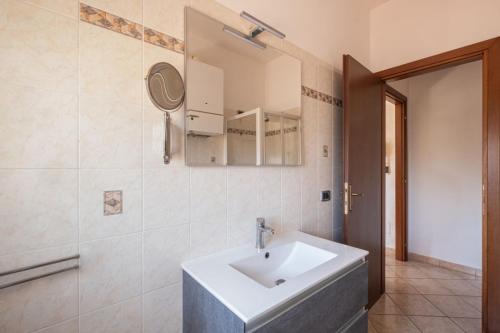 uma casa de banho com um lavatório branco e um espelho. em Alloggio Alfa em Civitavecchia