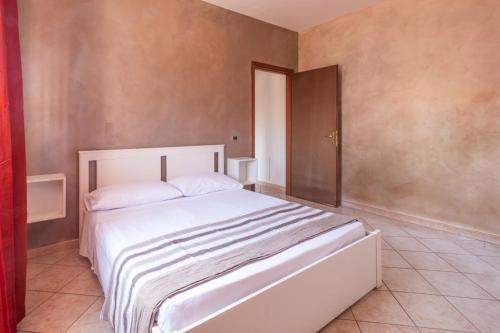um quarto com uma grande cama branca num quarto em Alloggio Alfa em Civitavecchia
