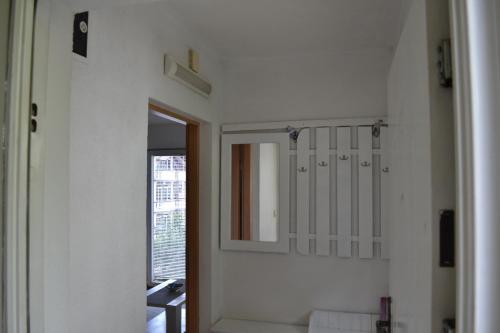 a white bathroom with a mirror and a sink at Apartment Lilac Sarajevo in Sarajevo