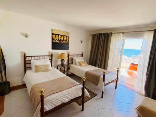 two beds in a room with a view of the ocean at Duplex Sea View by Albufeira Holidays in Albufeira