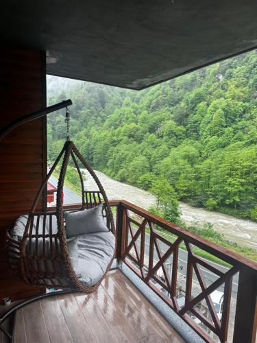 a porch with a hammock and a view of a river at Ria süit otel bungalov in Rize