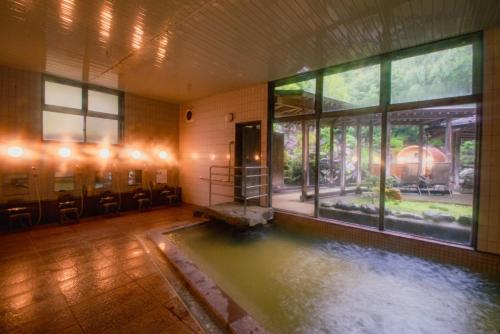 a room with a pool of water in a building at 湯の里いけもり別館 天座 in Himi