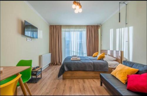 a bedroom with a bed and a table and a couch at New Gudauri Redco Premium Apartments in Gudauri