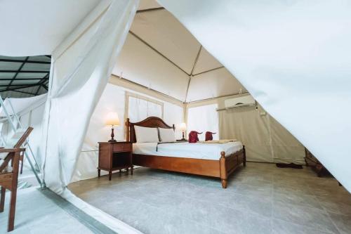 a bedroom with a bed in a tent at Country Cafe & Camping in Ban Cha-om