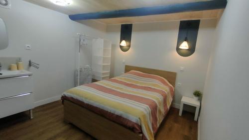 une petite chambre avec un lit et un lavabo dans l'établissement Studio rénové maison de village du Luberon, à Villelaure