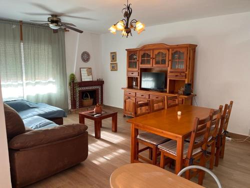 a living room with a couch and a table and a tv at Casa Costacabana Mar in La Cañada de San Urbano