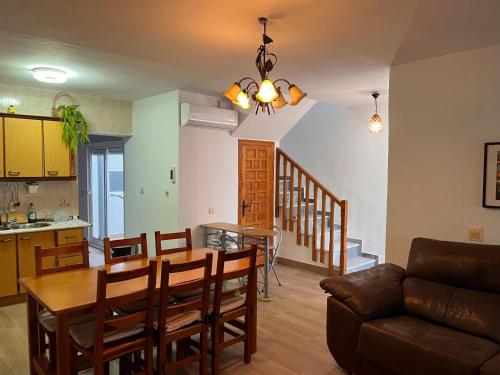 a kitchen and living room with a table and a couch at Casa Costacabana Mar in La Cañada de San Urbano