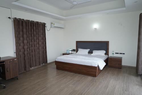 a bedroom with a bed and a desk in it at Madhav Kuteer B- 34 Vrindavan in Vrindāvan