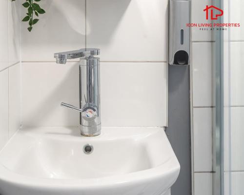a bathroom sink with a faucet on top of it at Arch-View Apartment 1 By Icon Living Properties Short Lets & Serviced Accommodation Wembley in London