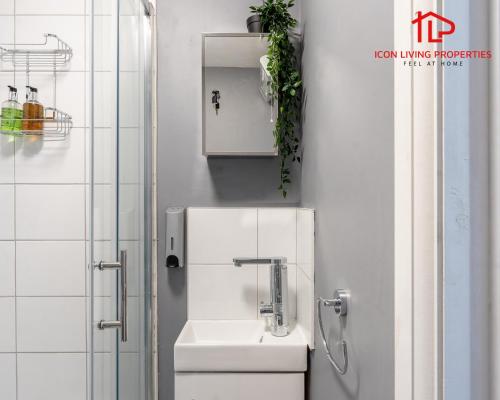 Baño blanco con lavabo y aseo en 1 Bedroom Arch-View Apartment 2 By Icon Living Properties Short Lets & Serviced Accommodation With Free Parking en Londres