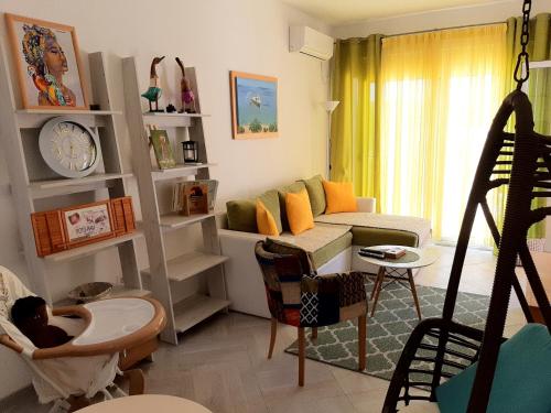 a living room with a baby sitting in a swing at Apartments Maljevic in Bar