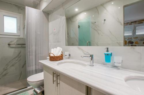 a bathroom with a sink and a toilet and a mirror at casa cabinari MANH in Yerolimin