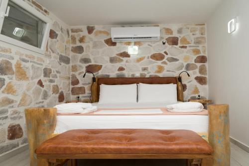 a bed in a room with a stone wall at casa cabinari MANH in Yerolimin