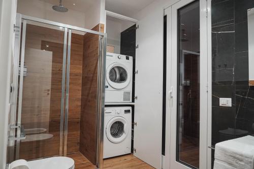 a bathroom with a washing machine and a washer and dryer at Casa Vacanza Stomar in Pozzallo