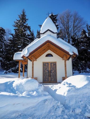 a small white chapel with a snow covered roof at Wellness & Naturresort Reischlhof in Wegscheid