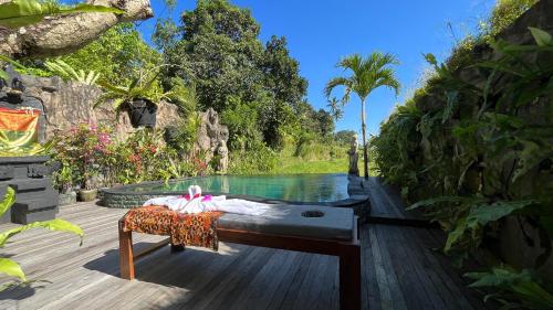 a bed sitting on a deck next to a pool at Puri Jumpungan Villas in Sidemen