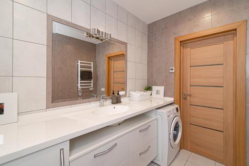 ein Badezimmer mit einem Waschbecken und einer Waschmaschine in der Unterkunft #stayhere - Spacious 1BDR with terrace in Paupys in Vilnius