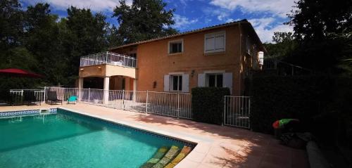 a house with a swimming pool in front of a house at Villa les chênes in Bargemon