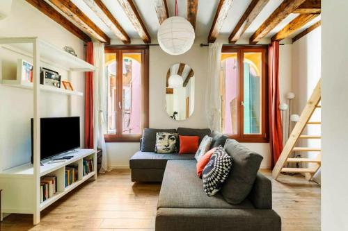 uma sala de estar com um sofá e uma televisão em Cà 3 Leoni - Romantic House in the heart of Venice em Veneza