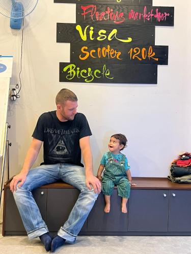 a man and a little boy sitting on a bench at WELKOM INN in Can Tho