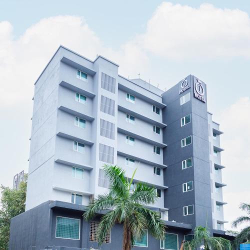 ムンバイにあるJ Hotel and Banquetsの前にヤシの木がある建物
