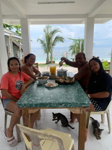 a group of people sitting around a table at Nitasnipahut Pamilacan island in Pamilacan