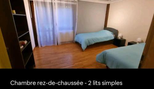 a small room with two beds and a window at Villa avec grand jardin, proche du centre-ville in Yverdon-les-Bains