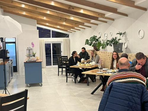 a group of people sitting at tables in a restaurant at Capri Sands Luxury Guest House in Capri Village