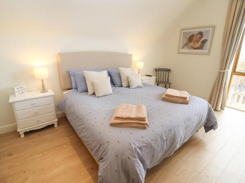 a bedroom with a bed with two towels on it at The Granary at Lane End Farm in Evesham