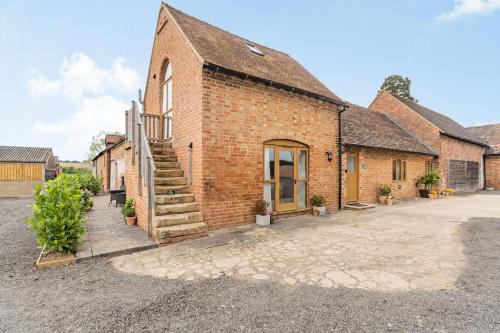 a brick building with a staircase outside of it at The Granary at Lane End Farm in Evesham