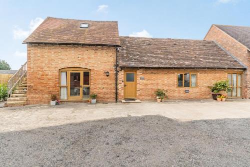 a brick house with a driveway in front of it at The Granary at Lane End Farm in Evesham