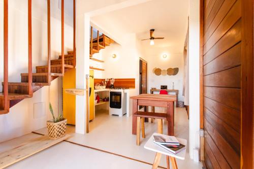 a room with a staircase and a table and a kitchen at Chalet du Kite in Prea
