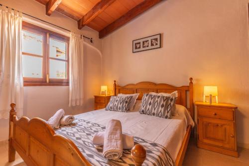 1 dormitorio con cama grande de madera y ventana en Acogedora finca con piscina en Lloseta, en Lloseta