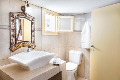 uma casa de banho com um lavatório, um WC e um espelho. em Kimolos em Sikinos