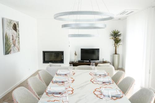 a white dining room with a table and chairs at Casa do Titó in Lanhelas