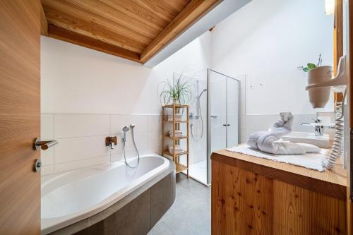 a bathroom with a bath tub and a sink at Ferienhaus Larch Soge Apt Paula in Racines