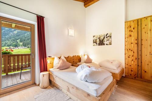 a bedroom with two beds and a large window at Ferienhaus Larch Soge Apt Paula in Racines
