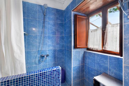 a blue tiled bathroom with a shower and a window at Casa Azul del Roque Negro in Santa Cruz de Tenerife